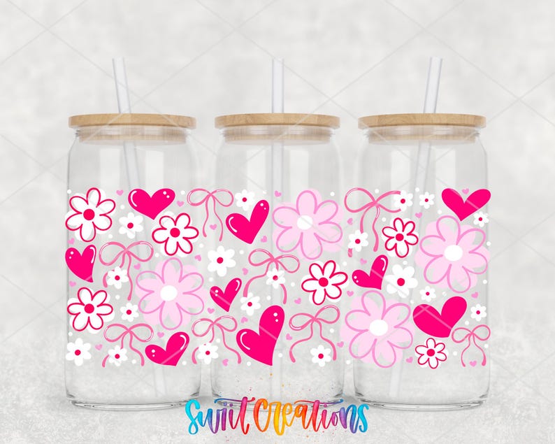 Three glass jars with wooden lids, each decorated with pink flowers, hearts, and bows.