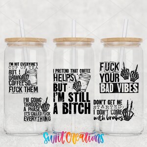 three glass tumblers with black text and illustrations on them. The text on the tumblers includes phrases such as "I'm not everyone's cup of tea", "But I drink coffee so I'm still a fuck", "Helps me", "But I'm still a fuck", "FUCK YOUR BAD VIBES", and "I'm going through a phase, I don't come with bruises".