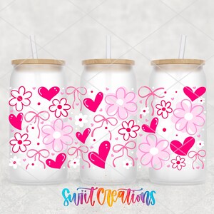 three frosted glass tumblers with pink and white floral designs, including hearts and flowers, along with straws.