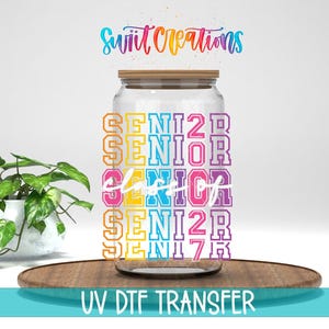 May include: A clear glass tumbler with a bamboo lid featuring a multi-colored graphic print that repeats the word SENIOR in block letters with the year 2027 and the script text class of layered over the center in white.