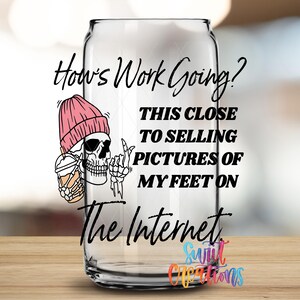 A glass can with text and an illustration of a skeleton wearing a pink beanie.