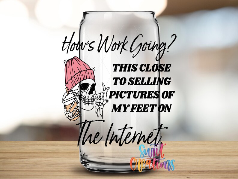 A glass can with text and an illustration of a skeleton wearing a pink beanie.