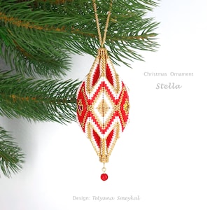 May include: A red, white, and gold beaded Christmas ornament shaped like a teardrop. The ornament is hanging from a gold chain and has a red bead at the bottom. The ornament is labeled "Christmas Ornament Stella".