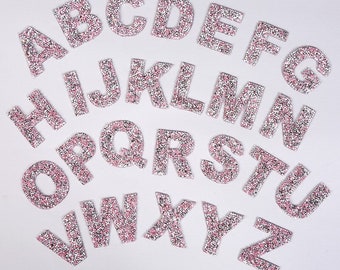 May include: A set of 26 pink and silver glitter letters, each letter of the alphabet is individually cut out and is approximately 2.5 cm tall.