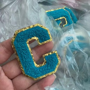 FERRO EM azul água 2,8 ”(7,1 cm) time do colégio Chenille personalizado com letras brilhantes douradas Patches feitos à mão/remendos iniciais do alfabeto A-Z