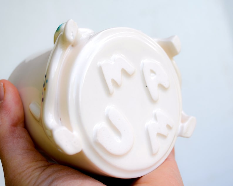 May include: White ceramic mug with the word "MAMA" embossed on the side.