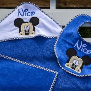 Puede incluir: Conjunto de toalla con capucha y babero azul con diseño de Mickey Mouse y el nombre "Nico" bordado en ambas piezas.