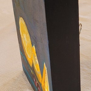 May include: A small, framed painting of a still life with lemons and red berries on a blue background. The painting is signed "Rigoni" in the lower right corner.