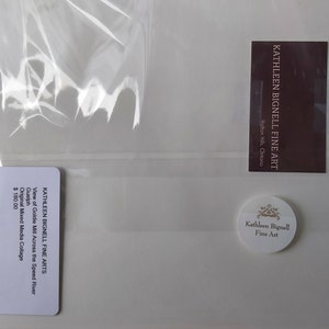 May include: A mixed media collage by Kathleen Bignell, titled "View of Goldie Mill Across the Speed River." The artwork is packaged in a clear plastic sleeve. The image includes a business card and a round sticker with the artist's name.