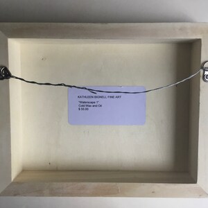 K&ouml;nnte beinhalten: Die R&uuml;ckseite eines gerahmten Gem&auml;ldes mit einem wei&szlig;en Passepartout und einem hellen Holzrahmen. Ein Drahtb&uuml;gel ist an der R&uuml;ckseite des Rahmens befestigt. Ein Etikett auf der R&uuml;ckseite des Rahmens lautet "KATHLEEN BIGNELL FINE ART" "Waterscape 1" Kaltwachs und &Ouml;l 55,00 &euro;