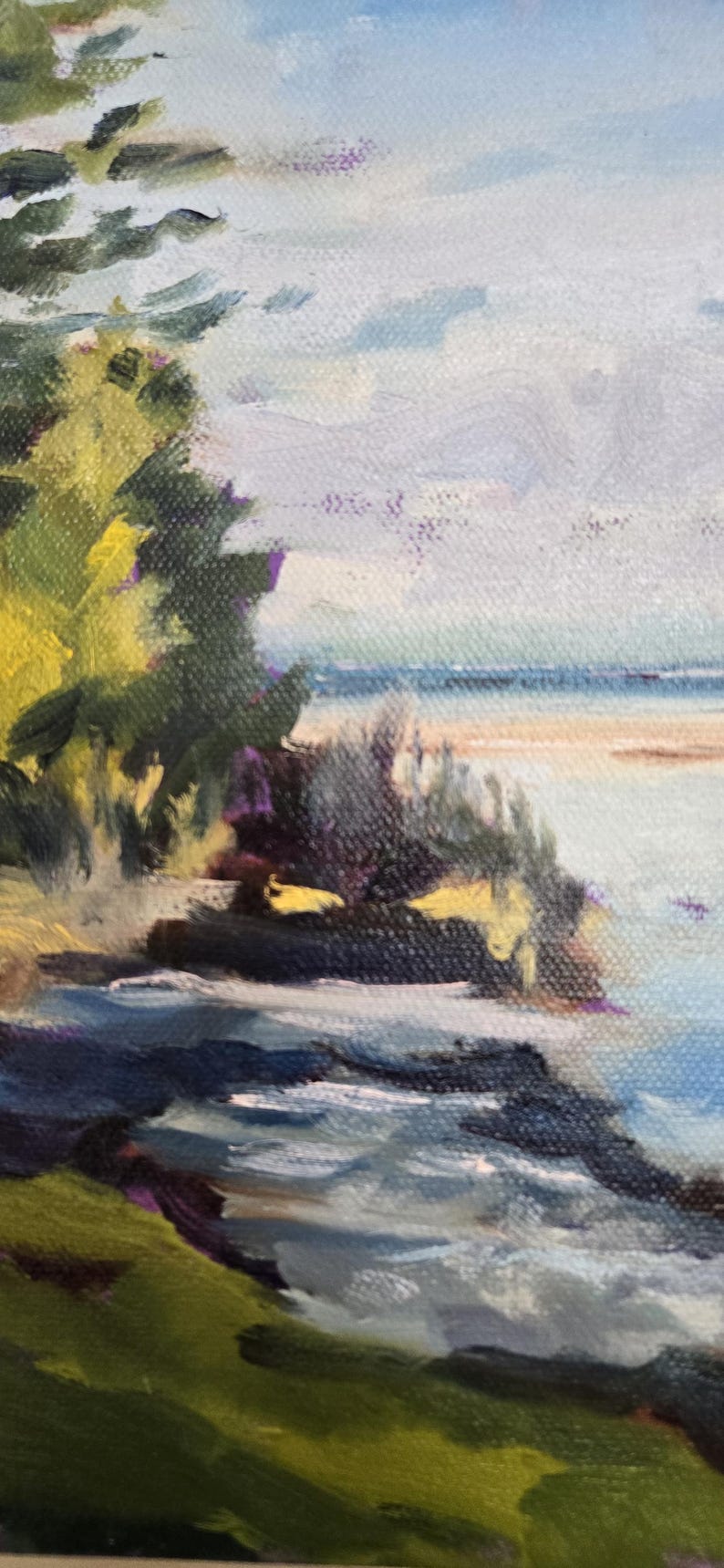 May include: A painting of a seascape with a green grassy hill in the foreground, a rocky shoreline, and a blue body of water in the background. The sky is a light blue with white clouds.