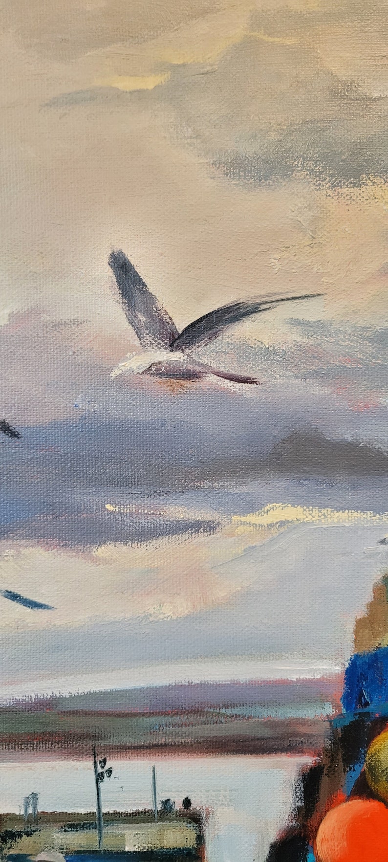 Op de afbeelding: Een olieverfschilderij dat een kustlandschap weergeeft met een bewolkte lucht en een vliegende zeemeeuw. Het kunstwerk heeft een gedempt kleurenpalet met tinten blauw, grijs en perzik. Het schilderij vangt een serene, natuurlijke omgeving.