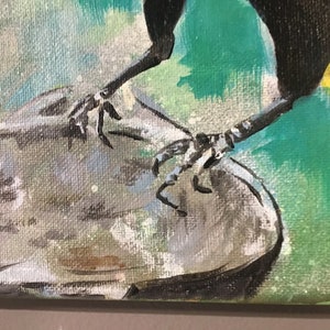 Op de afbeelding: Close-up van de poten van een vogel met zwarte klauwen, die op een grijs, getextureerd oppervlak zitten. De poten van de vogel zijn zwart en de achtergrond is een abstract schilderij in groen en geel.