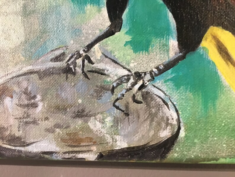 Op de afbeelding: Close-up van de poten van een vogel met zwarte klauwen, die op een grijs, getextureerd oppervlak zitten. De poten van de vogel zijn zwart en de achtergrond is een abstract schilderij in groen en geel.