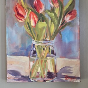 Puede incluir: Pintura al &oacute;leo de tulipanes rojos en un tarro de cristal transparente. Las flores tienen tallos y hojas verdes. El fondo es una mezcla de tonos azules, morados y blancos. La pintura est&aacute; firmada en la esquina inferior derecha.