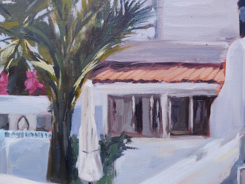 May include: A painting of a white building with a terracotta roof and a palm tree in the foreground. The building has a large window and a white door. The palm tree has green leaves and a brown trunk.