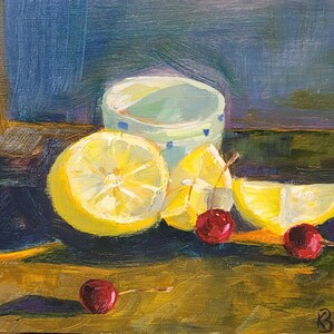Puede incluir: Pintura al &oacute;leo de naturaleza muerta con limones cortados, cerezas y una taza estampada. Los limones son de color amarillo brillante, y las cerezas son de color rojo intenso. La taza es blanca con detalles azules. El fondo es una mezcla de azul y verde.