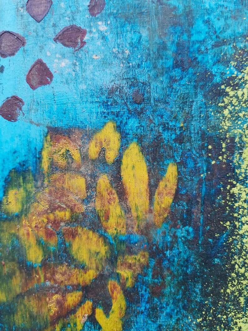 May include: Abstract painting with a blue background and yellow and brown shapes. The painting has a textured surface and a splattered effect.