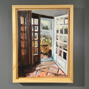 May include: A framed oil painting depicting a view from inside a home looking out through an open doorway. The doorway leads to a patio with a potted plant and a tiled floor. The painting is signed "Bignell" in the lower right corner.