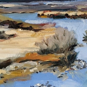 May include: A painting of a landscape with a blue body of water, brown sand, and green bushes. The water is in the foreground and the sand is in the background. The bushes are on the edge of the water.