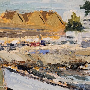 May include: Oil painting of a coastal scene with a boat in the foreground. The boat is painted in shades of blue and white. Buildings with tan roofs are in the background, under a light blue sky.