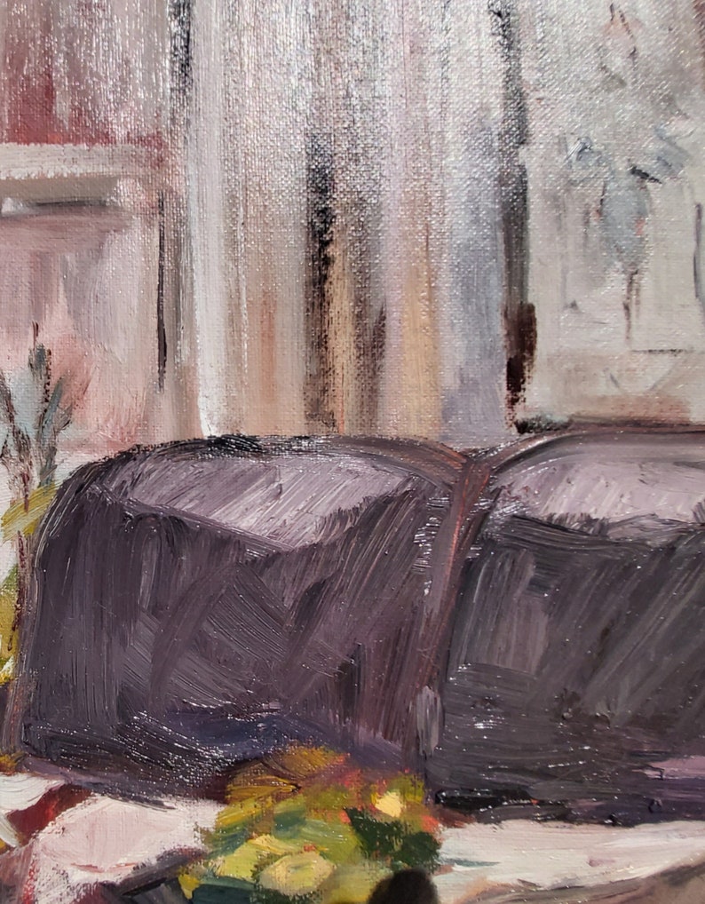 May include: A close-up of a dark purple loaf of bread sitting on a white surface with green and yellow vegetables in front of it.