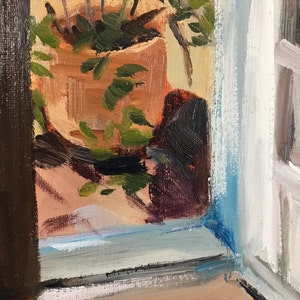 May include: A painting of a potted plant with green leaves in a terracotta pot, seen through a window with a blue and white frame. The plant is in focus, while the background is blurred.