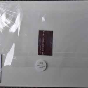 May include: A packaged artwork by Kathleen Bignell Fine Art. The artwork is a mixed media collage titled "View of Goldie Mill Across the Speed River" in Guelph. The package includes a sticker with the artist's name and a label with the artwork's title.
