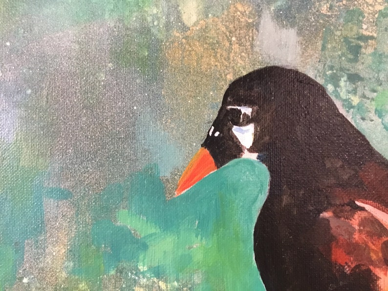 Op de afbeelding: Een close-up van een schilderij van een vogelkop. De vogel heeft een zwarte kop, een wit oog en een oranje snavel. De achtergrond is een abstract ontwerp in groen en blauw.