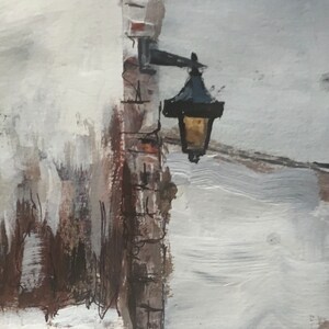 May include: A black street lamp with a white light fixture mounted on a brick wall. The wall is painted in shades of white and brown.