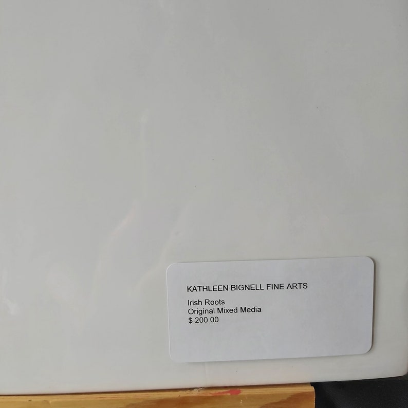 May include: White canvas with a white card attached to the bottom right corner. The card has black text that reads "KATHLEEN BIGNELL FINE ARTS", "Irish Roots", "Original Mixed Media", and "$200.00".
