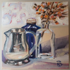 May include: A still life painting of a silver pitcher, a blue glass bottle, and a clear glass bottle with a bouquet of orange flowers in the background.