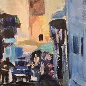 May include: An impressionistic oil painting of a European street scene. Buildings in shades of blue, beige, and brown line the street. Figures are suggested in the foreground, with a shop sign visible in the background.