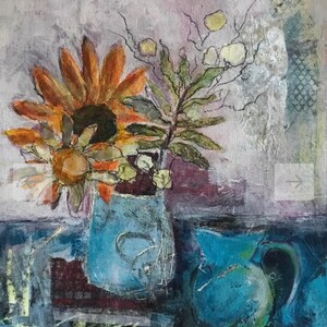 May include: A still life painting of a blue vase with a sunflower and other flowers. The vase is on a table with a blue pitcher in the background.