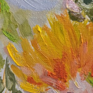 May include: Close-up of an abstract oil painting featuring vibrant brushstrokes. The artwork showcases a burst of yellow and orange hues, complemented by pink, purple, and green tones. The textured strokes create a dynamic and expressive floral composition.