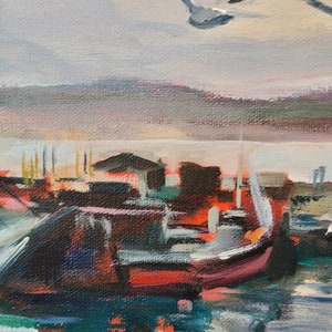 Op de afbeelding: Een impressionistisch schilderij van een haven. Een rode en zwarte boot staat op de voorgrond, met meeuwen die eroverheen vliegen. De lucht is een mix van grijs, roze en blauw.