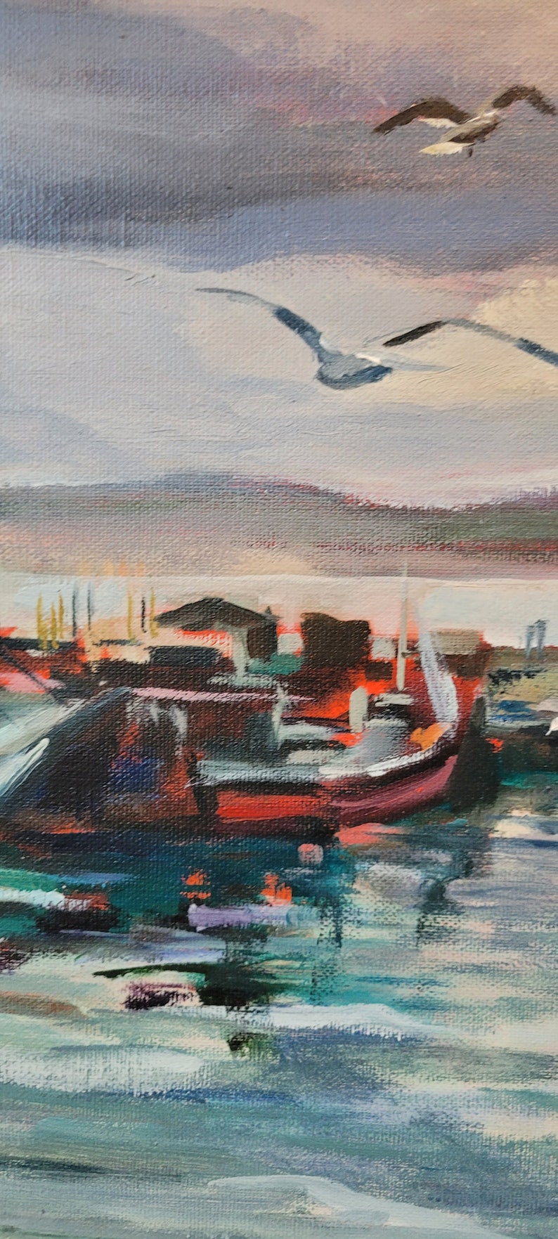 Op de afbeelding: Een impressionistisch schilderij van een haven. Een rode en zwarte boot staat op de voorgrond, met meeuwen die eroverheen vliegen. De lucht is een mix van grijs, roze en blauw.
