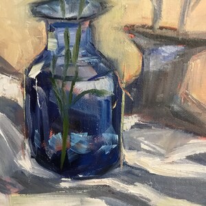 May include: An oil painting depicts a still life with a dark blue glass vase holding green stems. The vase sits on a white and gray striped cloth. A second vase is partially visible in the background. The artist's signature is in the lower right corner.