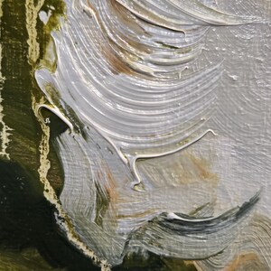 May include: Close-up of an abstract oil painting with thick brushstrokes. The artwork features a blend of colors, including white, gray, green, and brown. The texture is visible, with the paint applied in a layered, impasto style.