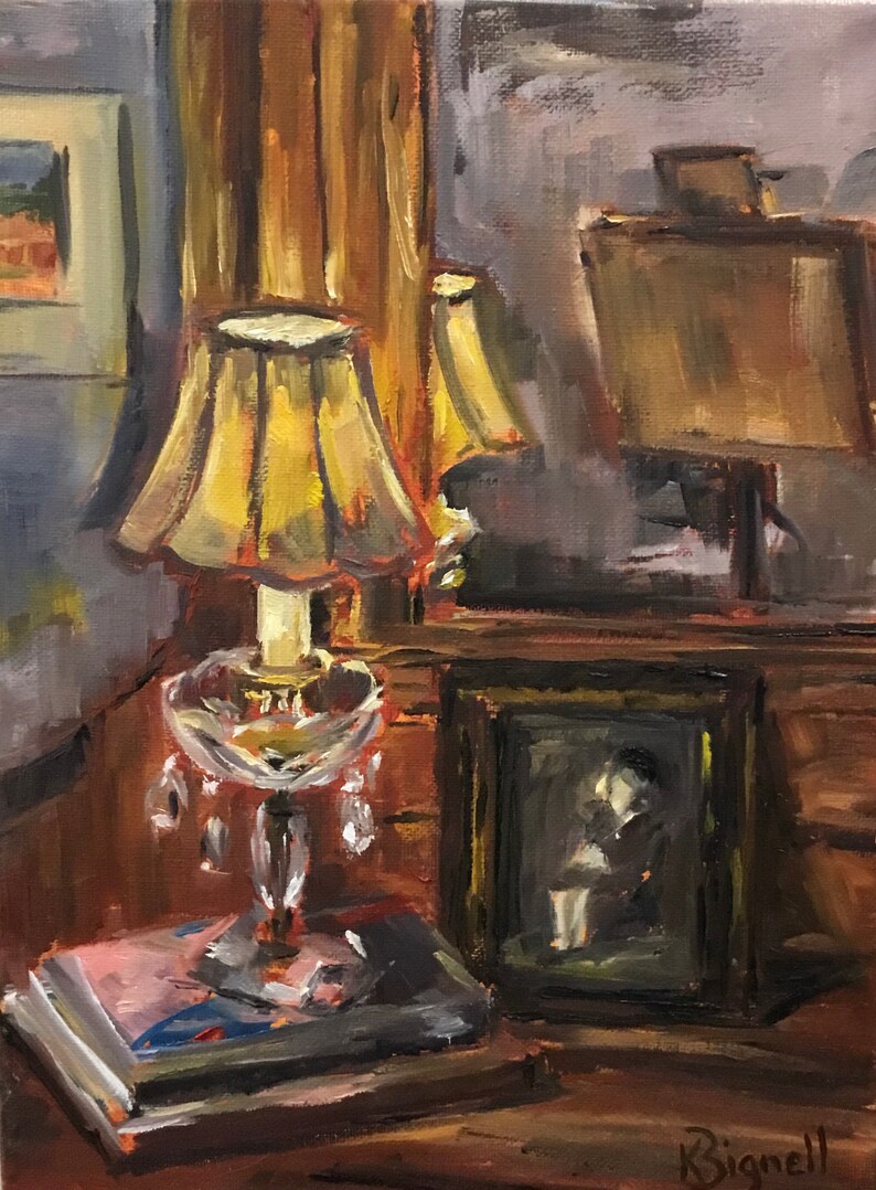 May include: A painting of a still life with a lamp, books, and a framed photo. The lamp has a yellow shade and a crystal base. The books are stacked on a table, and the photo is of a person sitting in a chair. The painting is done in a loose, impressionistic style.