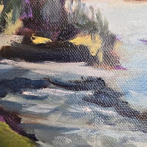 May include: A painting of a seascape with a rocky shoreline and a blue sky with white clouds. The water is a light blue and the rocks are a dark gray. The sky is a light blue with white clouds.