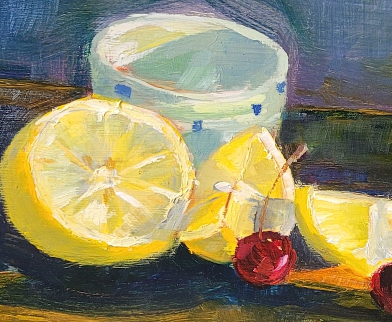 Puede incluir: Una pintura al &oacute;leo de naturaleza muerta con limones en rodajas, cerezas y una taza verde claro con detalles azules. Los limones son amarillos y las cerezas son rojas. El fondo es azul oscuro y verde.