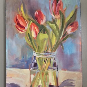 Puede incluir: Pintura al &oacute;leo de tulipanes rojos en un tarro de cristal transparente. Las flores tienen tallos y hojas verdes. El fondo es una mezcla de azul, morado y blanco. La pintura est&aacute; firmada en la esquina inferior derecha.