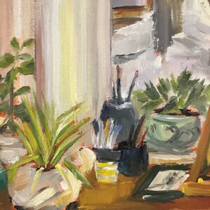 Puede incluir: Una pintura al &oacute;leo representa una naturaleza muerta con una ventana, plantas y materiales de arte. Un jarr&oacute;n blanco contiene una planta verde con hojas largas. Pinceles y l&aacute;pices est&aacute;n en un recipiente negro. Una peque&ntilde;a imagen enmarcada descansa sobre una superficie de madera.