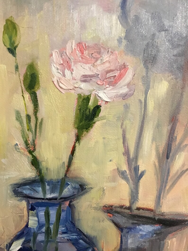 May include: Oil painting of a pink carnation flower in a blue vase. The flower has multiple layers of petals and is surrounded by green stems and buds. The background is a soft yellow and the painting has a textured appearance.