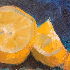 May include: A still life painting of two lemon halves and three red grapes on a dark blue background. The lemons are sliced open and show the yellow flesh inside. The grapes are clustered together and have a deep red color.
