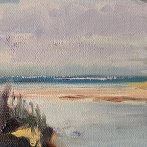 May include: A painting of a seascape with a blue sky and a sandy beach. The water is a light blue and the sand is a light brown. There are some green bushes in the foreground.