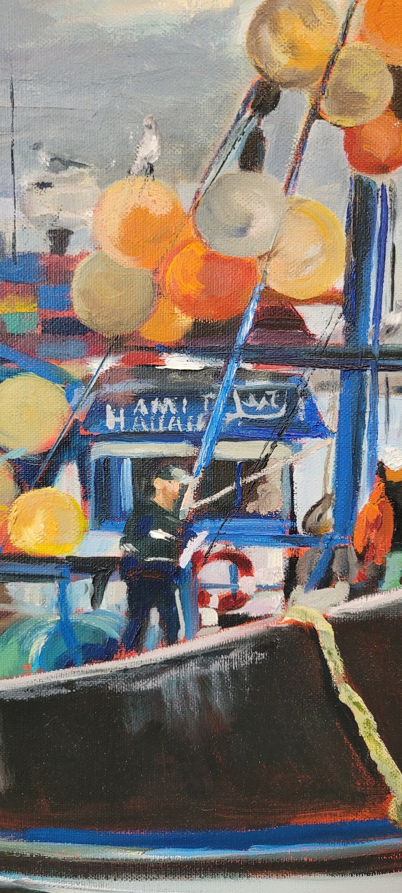 Op de afbeelding: Olieverfschilderij van een vissersboot met het woord "HAMILTON" zichtbaar. De zwarte boot heeft blauwe details en oranje en gele boeien. Een persoon staat op de boot. De lucht is grijs.