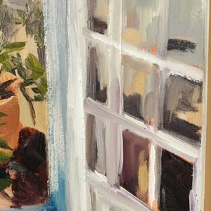 May include: A close-up of a window with white painted trim and a view of a potted plant through the glass. The window is open and the curtains are drawn back.
