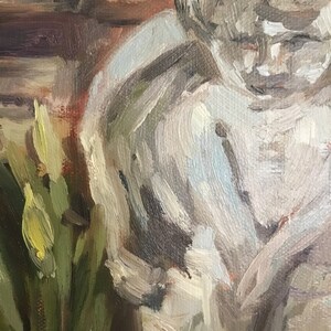 May include: A close-up of a painting depicting a person with a white shirt and a bouquet of yellow flowers in the foreground.